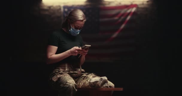 Military woman in mask using smartphone — Stock Video