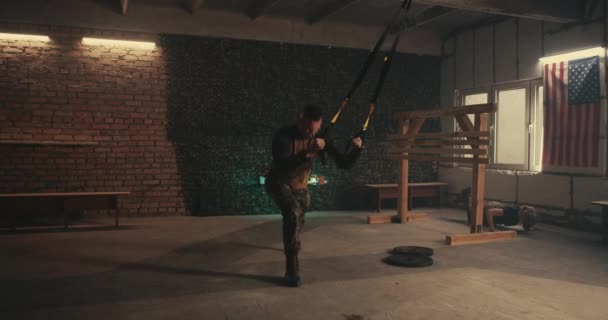 Mand soldat gør TRX motion i gymnastiksalen – Stock-video