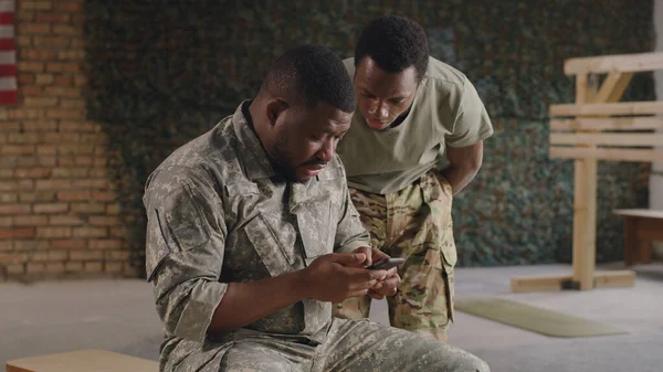 Militares negros usando smartphone en el gimnasio juntos — Foto de Stock