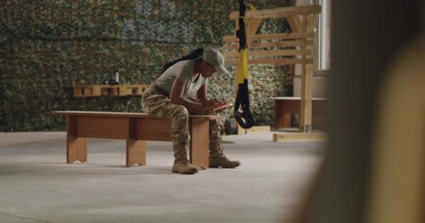 体育館でスマホを使う黒人軍人女性 — ストック動画