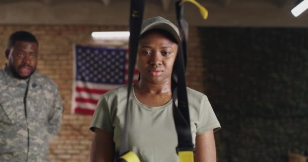 Чорношкіра військова жінка слухає тренера і відпочиває в спортзалі — стокове відео