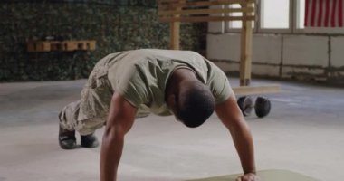 Spor salonunda şınav çeken siyah bir asker.