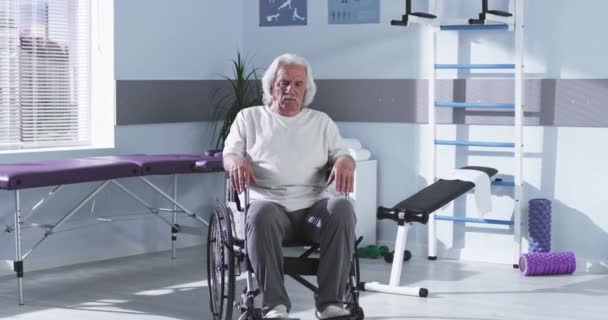 Лікар врожаю штовхає інвалідне крісло з пацієнтом старшого віку — стокове відео