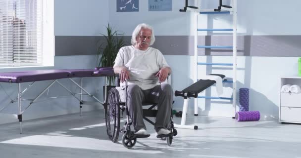 Starší muž na invalidním vozíku v rehabilitačním centru