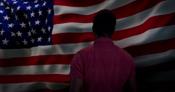 Black man smiling for camera against American flag — Stock Video