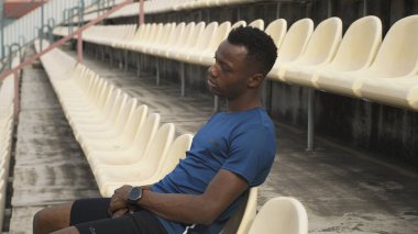 Afrikalı Amerikalı sporcu stadyumda dinleniyor.
