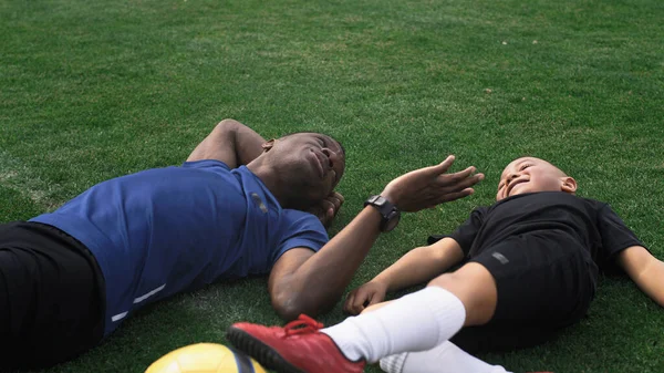 Diverso padre e hijo jugando en el campo de fútbol durante el descanso — Foto de Stock