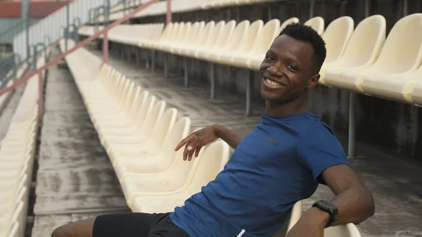 Feliz deportista negro descansando en el estadio — Foto de Stock