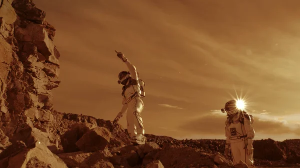 Astronauci wspinają się na skały i odwracają wzrok na Marsie — Zdjęcie stockowe