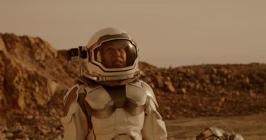 Dişi astronot Mars 'ın arazisinde çekim yapıyor.