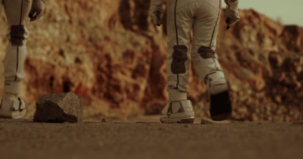 Nerozpoznatelní astronauti kráčející po vyprahlé zemi Marsu — Stock video