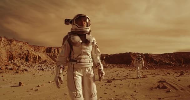 Vrouwelijke astronaut loopt op Mars bij collega — Stockvideo