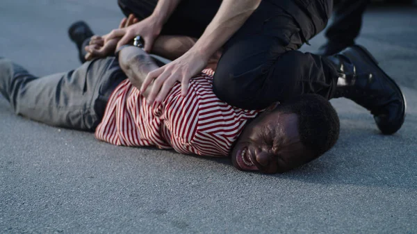 Policía poniendo esposas en llorando hombre negro — Foto de Stock