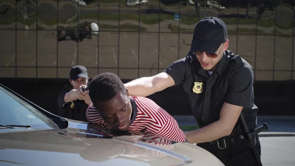Des policiers avec une arme arrêtant un conducteur noir — Photo