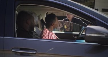 Kadın polis memuru siyah adamların belgelerini kontrol ediyor.