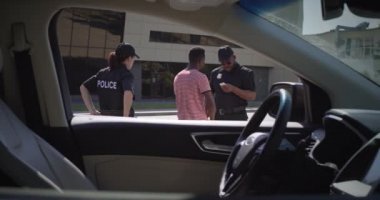 Çeşitli polis memurları siyah sürücünün belgelerini kontrol ediyor.