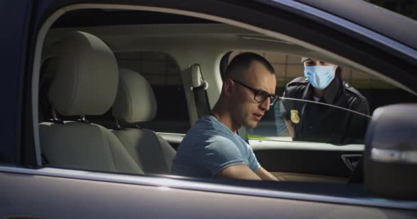 Agent de police vérifiant le conducteur masculin pendant la pandémie — Video