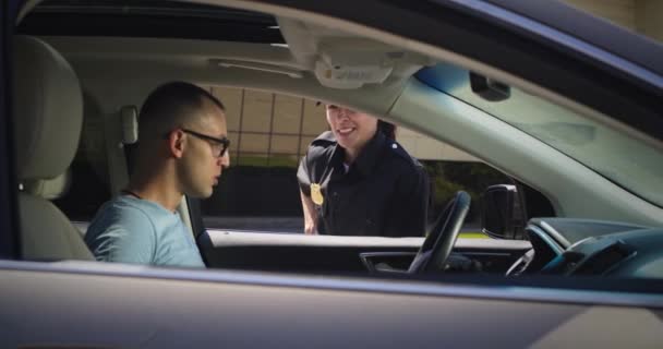 Vänlig polis kontrollerar körkort för man — Stockvideo