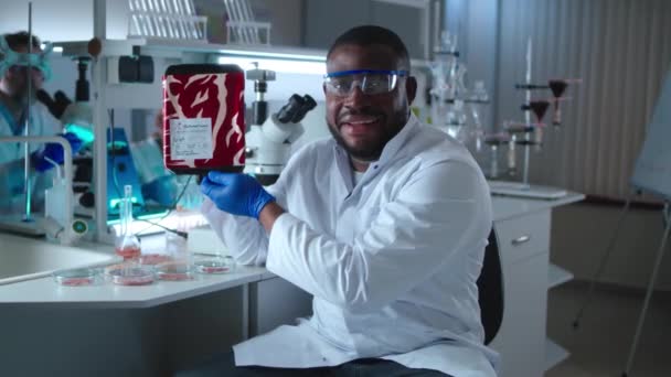 Pria Afrika-Amerika yang bahagia menunjukkan daging lab — Stok Video