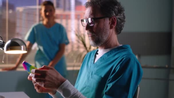 Dokter bermain Pop It mainan dan berbicara dengan rekan — Stok Video