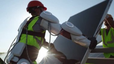 Erkek teknisyenler güneşli bir günde güneş pili kuruyorlar