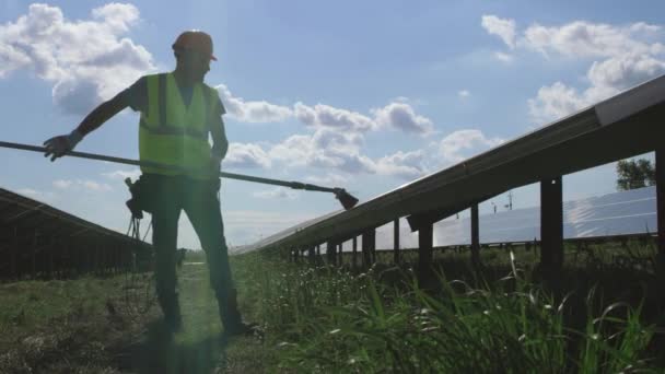 태양 전 지판에서 먼지를 제거하는 남성 기술자 빗자루 로 — 비디오