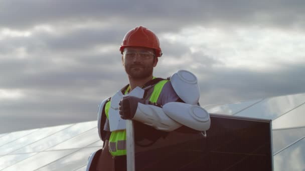 Man technicus met fotovoltaïsch paneel op bewolkte dag — Stockvideo