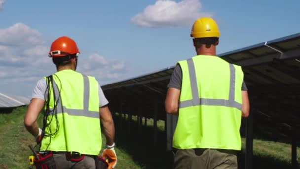 Μη αναγνωρίσιμοι εργαζόμενοι που εξετάζουν μαζί ηλιακούς συλλέκτες — Αρχείο Βίντεο