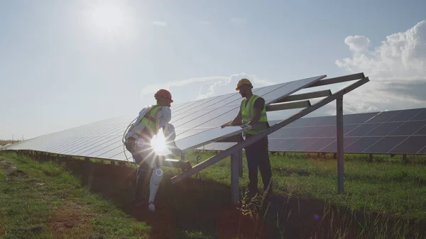 Engenheiros masculinos instalando painéis solares juntos — Fotografia de Stock