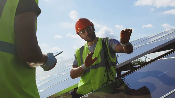 Ingeniero masculino mostrando panel fotovoltaico al inspector —  Fotos de Stock