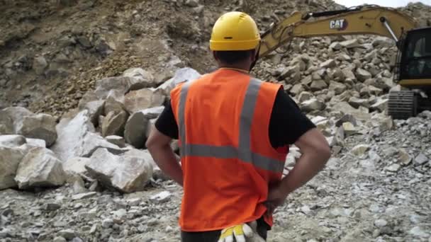Unrecognizable engineer watching excavator digging stone — Stock video