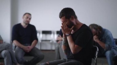 Bağımlılar için grup toplantısı sırasında ağlayan umutsuz bir adam.