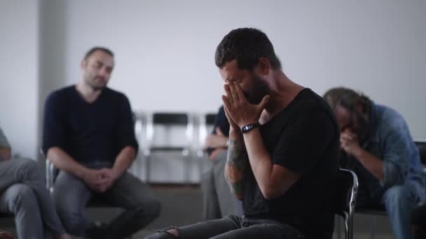 Отчаянный мужчина плачет во время группового собрания для наркоманов — стоковое видео