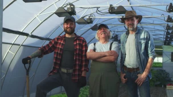 Cheerful multi generational farmers in hothouse — Stock Video