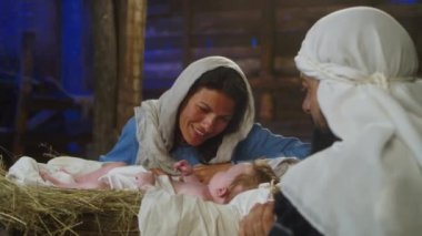 Meryem, Yusuf 'un yanında İsa bebekle konuşuyor.