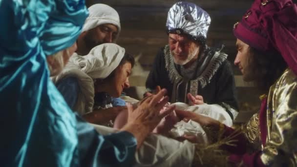 Magi and parents speaking over manger with baby Jesus — Stock Video