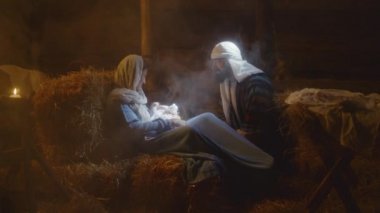 Joseph ahırda Meryem ve bebek İsa ile konuşuyor.