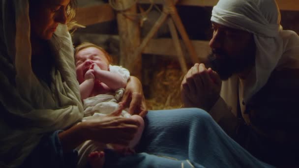 Joseph and Mary with crying baby Jesus near stalls — ストック動画