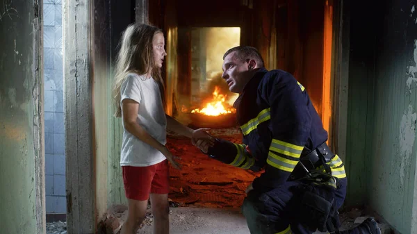 Menina falando com bombeiro em prédio em chamas — Fotografia de Stock