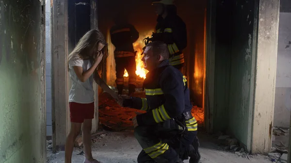 Menina falando com bombeiro em prédio em chamas — Fotografia de Stock