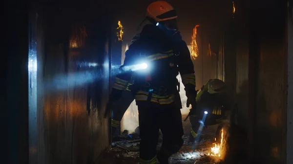 Brandmän undersöker brinnande korridor under räddningsinsatsen — Stockfoto