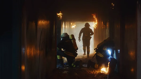 Brandmän undersöker brinnande korridor under räddningsinsatsen — Stockfoto