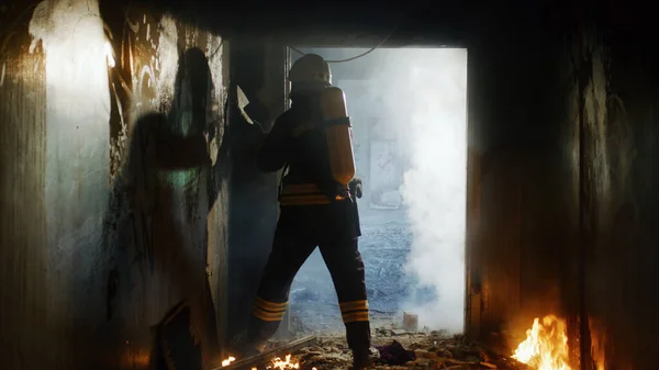 Unrecognizable fireman breaking doorway with axe — Stock Photo, Image