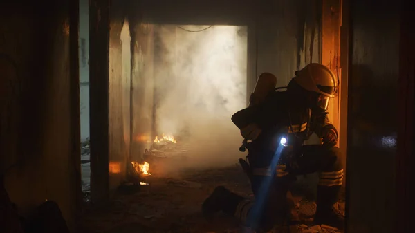 Firefighters running through hallway of burning building — ストック写真