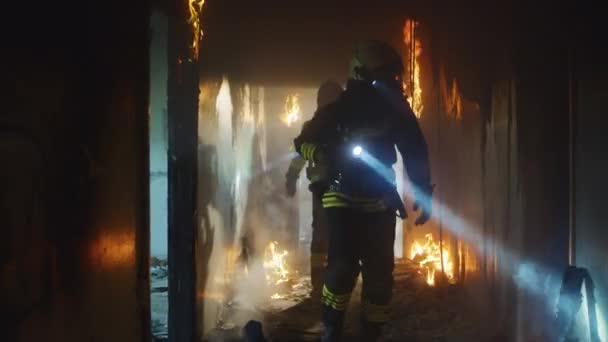 Brandweerlieden die brandgangen onderzoeken tijdens reddingsoperaties — Stockvideo