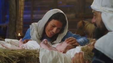 Meryem, Yusuf 'un yanında İsa bebekle konuşuyor.