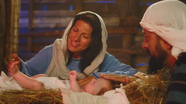 Maria e José beijando e tocando o bebê Jesus — Fotografia de Stock