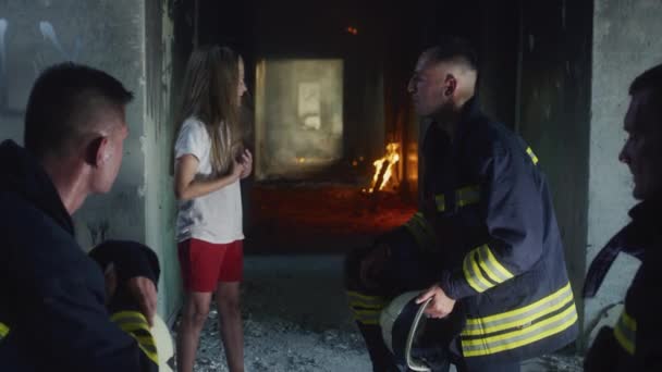 Firemen interrogating saved girl in burning building — Stock Video