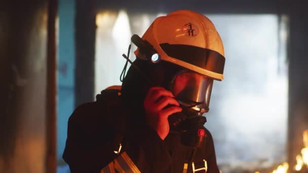 Bombero hablando por radio en edificio en llamas — Vídeos de Stock