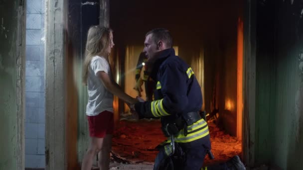 Firemen giving toy to girl in burning building — Stock Video